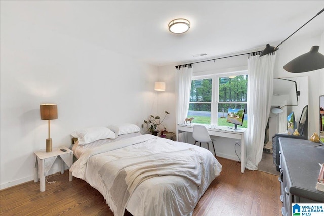 bedroom with dark wood-type flooring