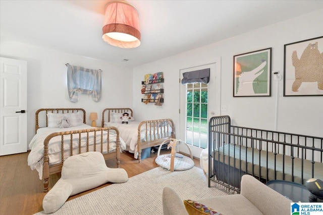 bedroom featuring hardwood / wood-style floors and access to outside