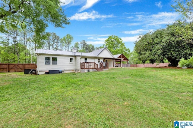 rear view of house featuring a lawn, a wooden deck, and central AC