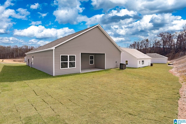 back of house with central AC unit, a lawn, and a patio