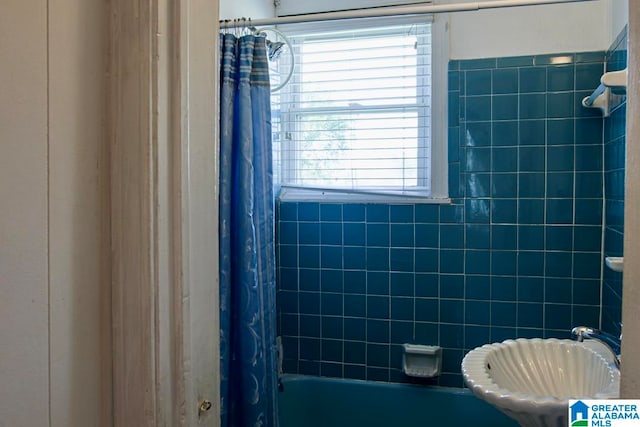 bathroom with a healthy amount of sunlight and shower / bath combination with curtain