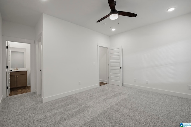 spare room featuring ceiling fan, dark carpet, and sink