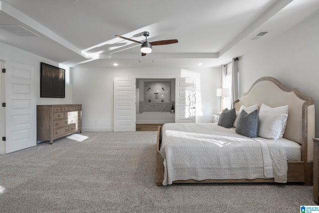 bedroom with ensuite bath, light carpet, and ceiling fan