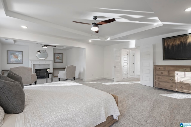 carpeted bedroom with ceiling fan and a fireplace