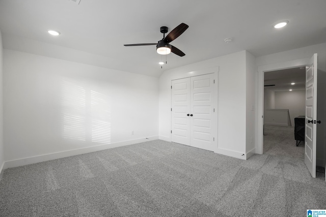 unfurnished bedroom with light colored carpet, ceiling fan, and a closet