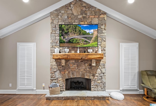 living room featuring a stone fireplace and wood-type flooring