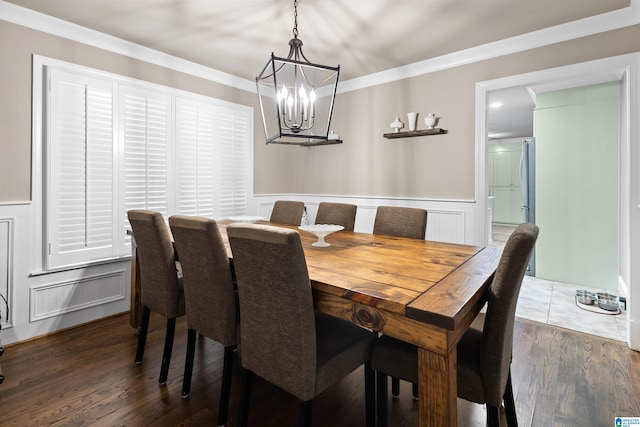 dining room featuring ornamental molding, an inviting chandelier, and dark wood-type flooring