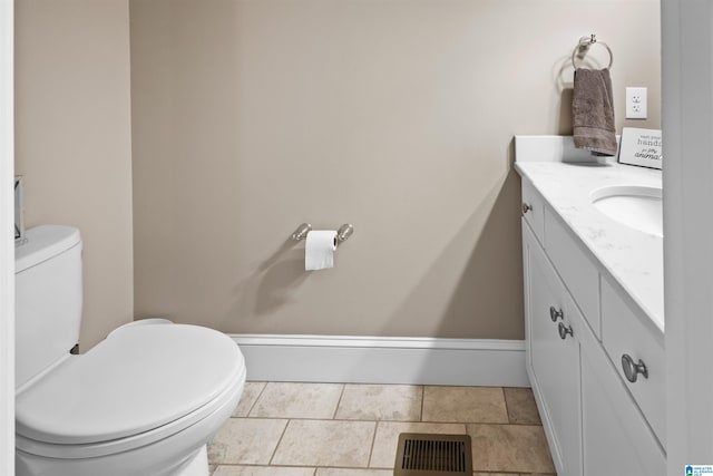 bathroom featuring toilet, tile flooring, and vanity