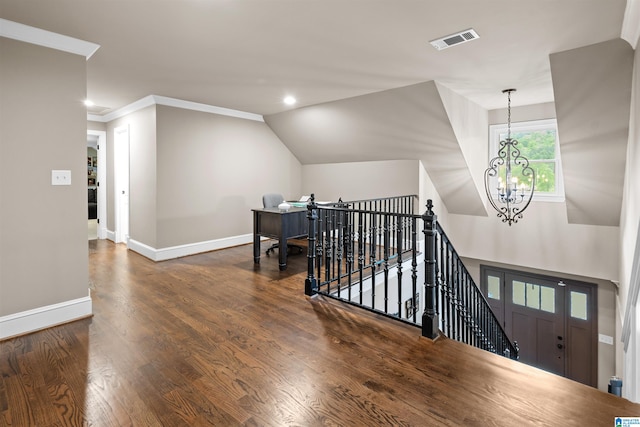 corridor featuring ornamental molding, an inviting chandelier, dark wood-type flooring, and vaulted ceiling