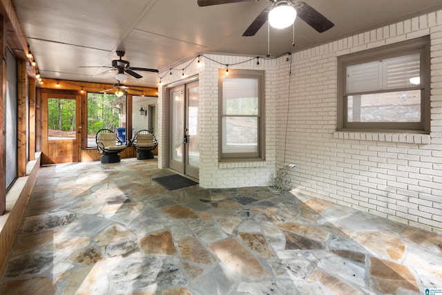 unfurnished sunroom with ceiling fan