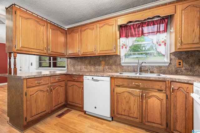 kitchen with light hardwood / wood-style flooring, backsplash, sink, dishwasher, and a textured ceiling