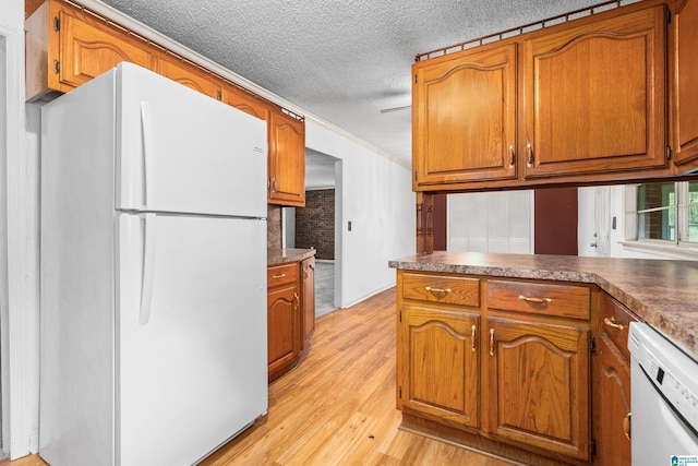 kitchen featuring white appliances, crown molding, light wood-type flooring, and a textured ceiling