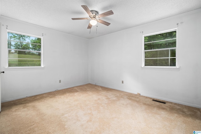 carpeted spare room featuring ceiling fan and a textured ceiling