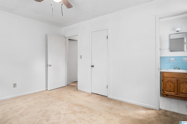 unfurnished bedroom featuring light colored carpet, sink, ceiling fan, and ornamental molding