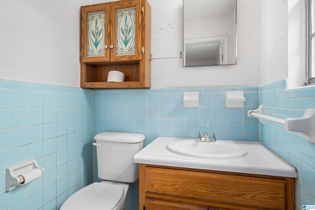 bathroom featuring backsplash, tile walls, toilet, and vanity with extensive cabinet space