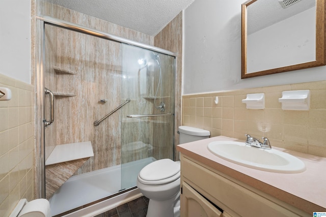 bathroom with tile walls, oversized vanity, toilet, a textured ceiling, and tasteful backsplash