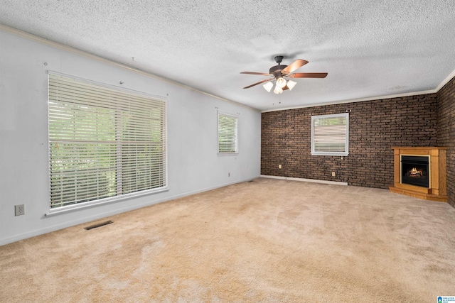 unfurnished living room featuring carpet floors, ceiling fan, brick wall, and a brick fireplace