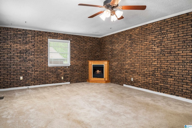 unfurnished living room with brick wall, ornamental molding, a brick fireplace, and ceiling fan