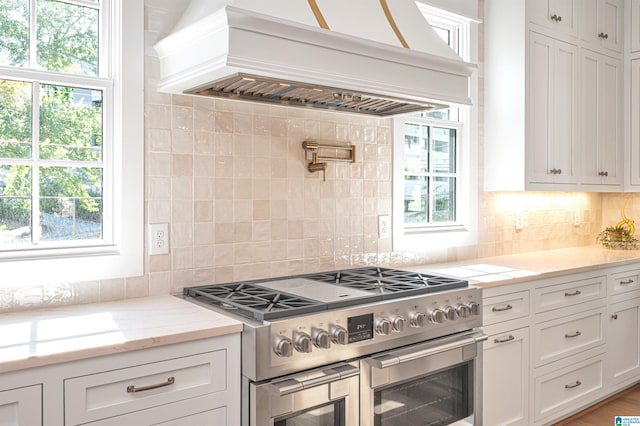 kitchen featuring tasteful backsplash, plenty of natural light, and range with two ovens