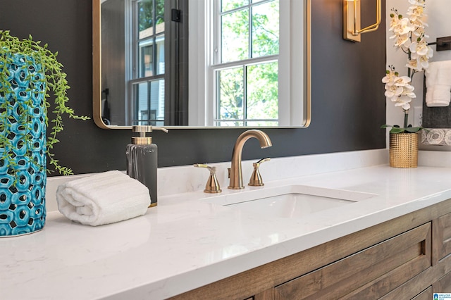 bathroom featuring a healthy amount of sunlight and vanity with extensive cabinet space