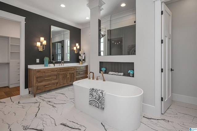 bathroom with crown molding, decorative columns, a bathtub, hardwood / wood-style flooring, and vanity