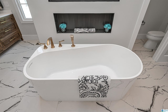 bathroom featuring tile floors, vanity, toilet, and a tub