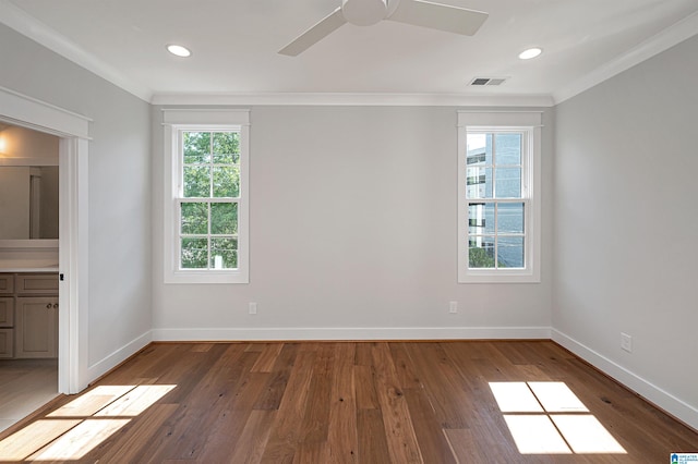 spare room featuring crown molding, plenty of natural light, ceiling fan, and hardwood / wood-style floors