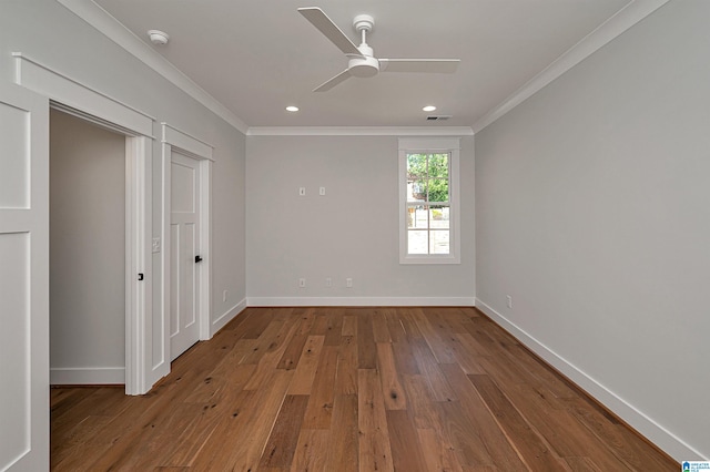 spare room featuring hardwood / wood-style flooring, ornamental molding, and ceiling fan