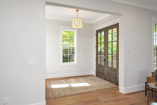 foyer entrance with french doors, ornamental molding, and wood-type flooring