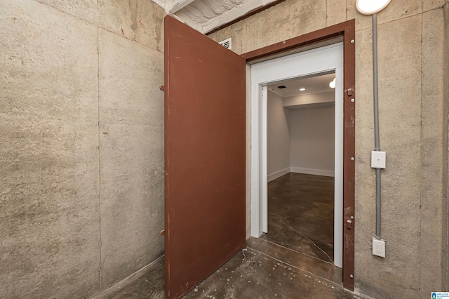 hall with concrete flooring