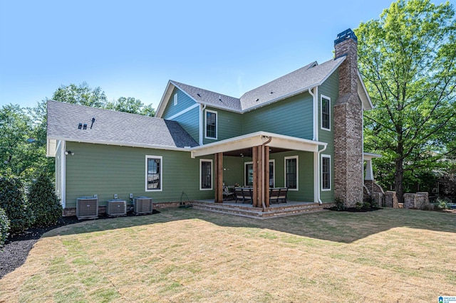 rear view of house with a patio, central air condition unit, and a lawn