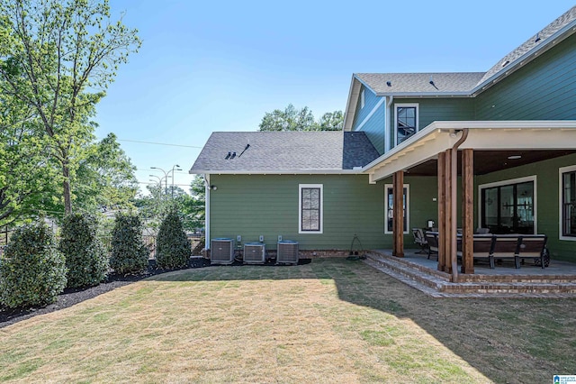 rear view of house with a yard, a patio area, and central air condition unit