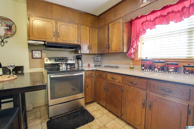 kitchen featuring stainless steel range with electric stovetop, light tile flooring, and ornamental molding