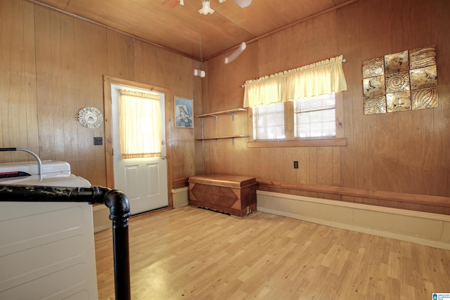 interior space featuring wood ceiling, light hardwood / wood-style flooring, washing machine and dryer, and wooden walls