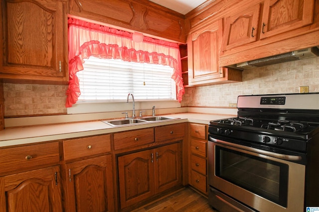 kitchen with backsplash, stainless steel gas range, dark hardwood / wood-style flooring, and sink