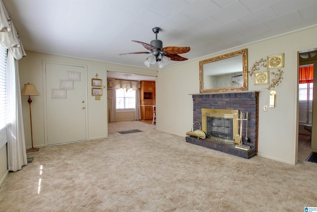 unfurnished living room featuring ceiling fan, a brick fireplace, and carpet flooring