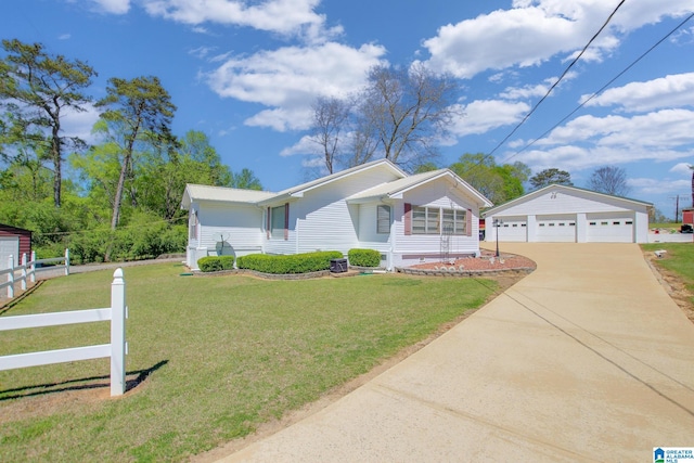 view of front of home with a front yard, a garage, and an outdoor structure