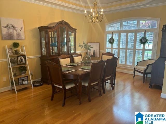 dining space featuring a healthy amount of sunlight, a notable chandelier, and hardwood / wood-style flooring