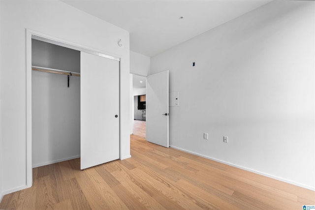 unfurnished bedroom featuring light wood-type flooring and a closet