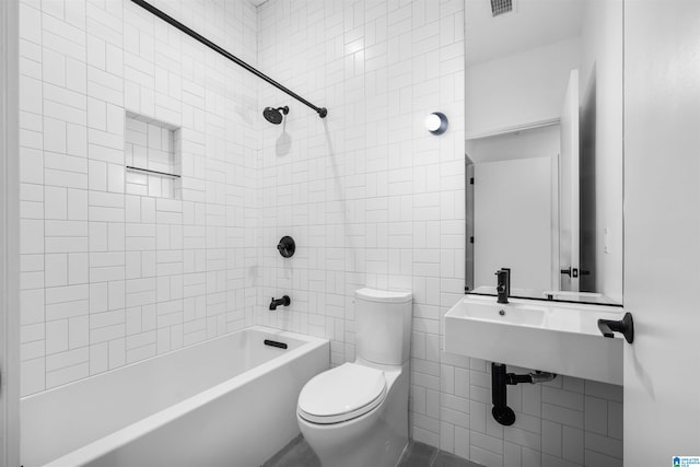 bathroom with tiled shower / bath and toilet