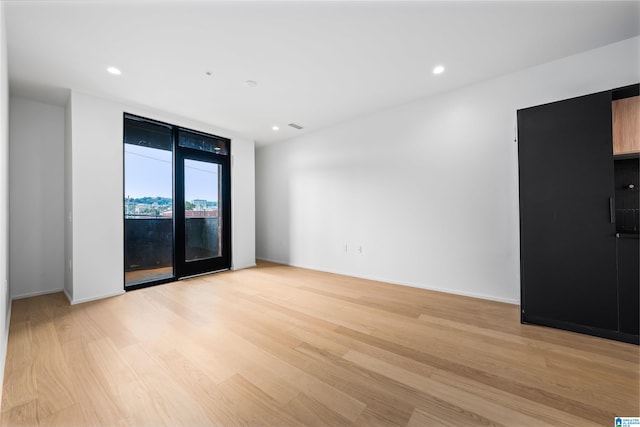 unfurnished room with light wood-type flooring