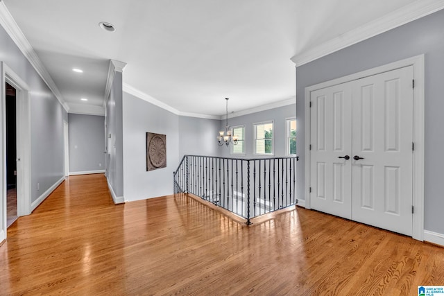 interior space with light wood-type flooring, a chandelier, and ornamental molding