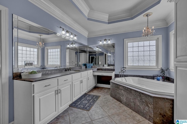 bathroom with tile floors, vanity, a tub, ornamental molding, and a tray ceiling