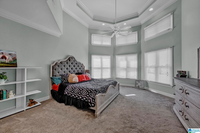 bedroom featuring light colored carpet, ornamental molding, a high ceiling, and a tray ceiling