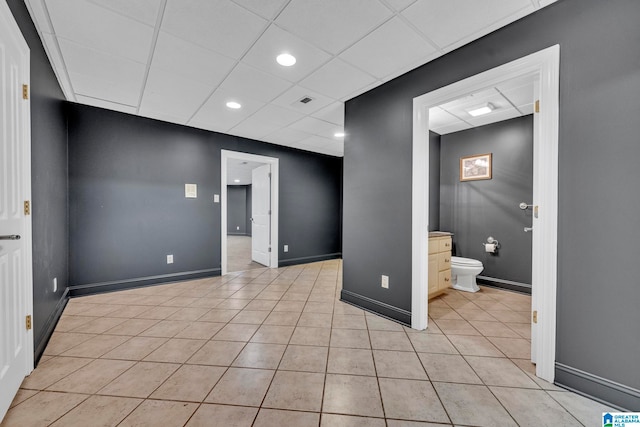 tiled empty room with a paneled ceiling