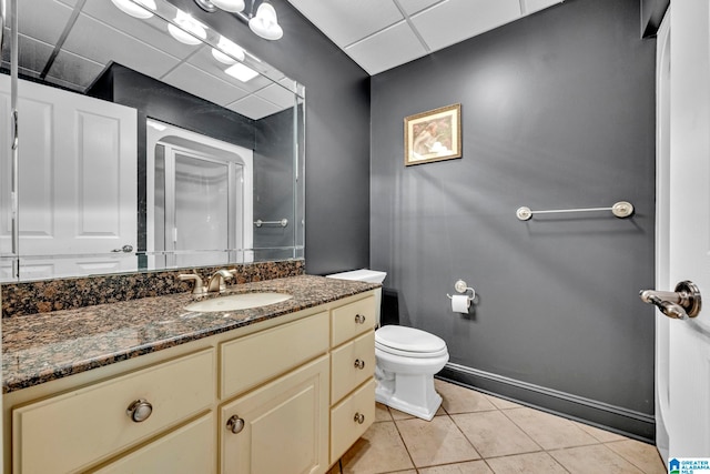 bathroom with toilet, oversized vanity, a paneled ceiling, and tile flooring