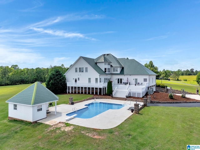 rear view of house featuring a yard, a pool side deck, and a patio area