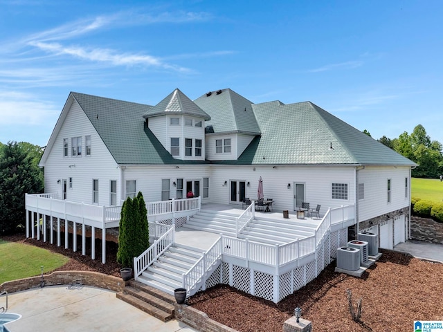 back of house with a deck and a patio