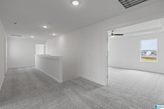 spare room with baseboards, visible vents, and light colored carpet