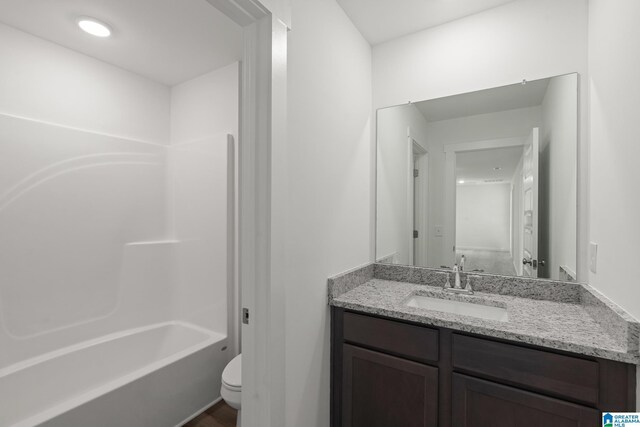 full bathroom featuring bathing tub / shower combination, vanity, and toilet